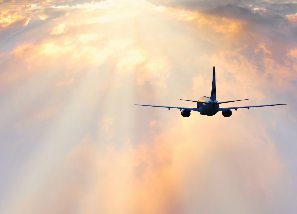 Passenger plane above the colorful clouds.