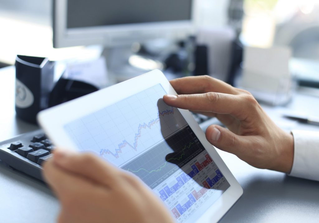 Business person analyzing financial statistics displayed on the tablet screen