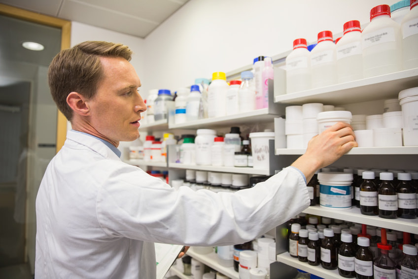 pharmacist taking medicine from shelf